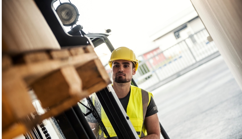 Operador de empilhadeiras erguendo pallets