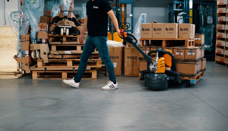 Homem usando uma paleteira para movimentar cargas